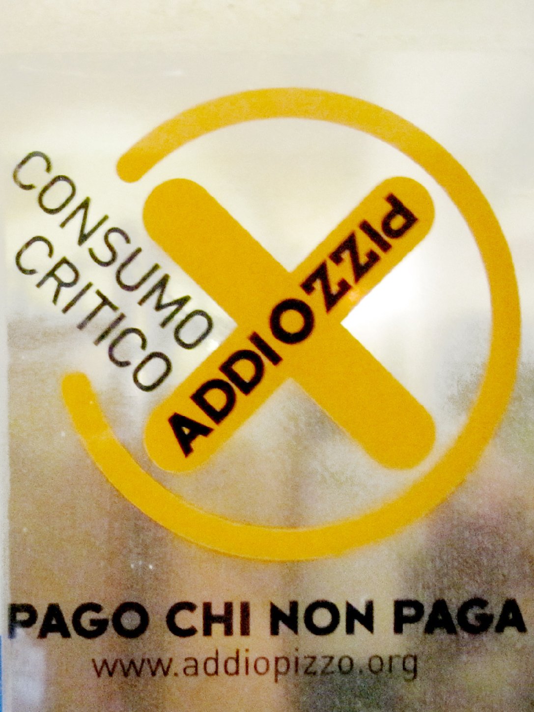 The Addiopizzo sticker on the door of a restaurant or hotel in Sicily tells you the establishment does not pay extortion money to the Mafia. Photo: The Kitchen Sisters