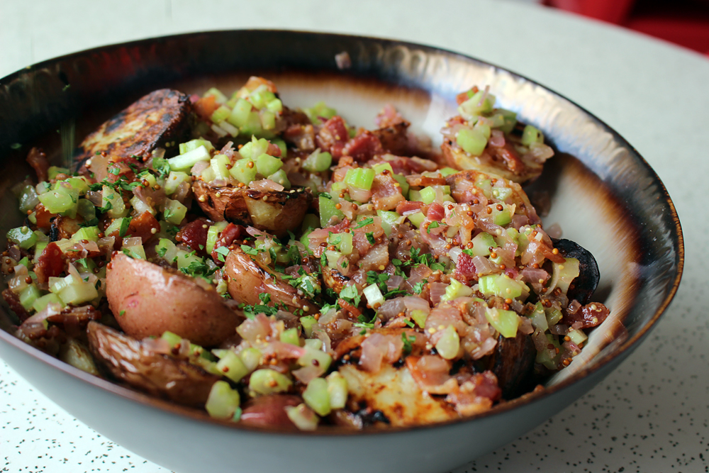 Pour the warm bacon vinaigrette over the grilled potatoes, add parsley, let rest 15 min, stir before serving. Photo: Wendy Goodfriend