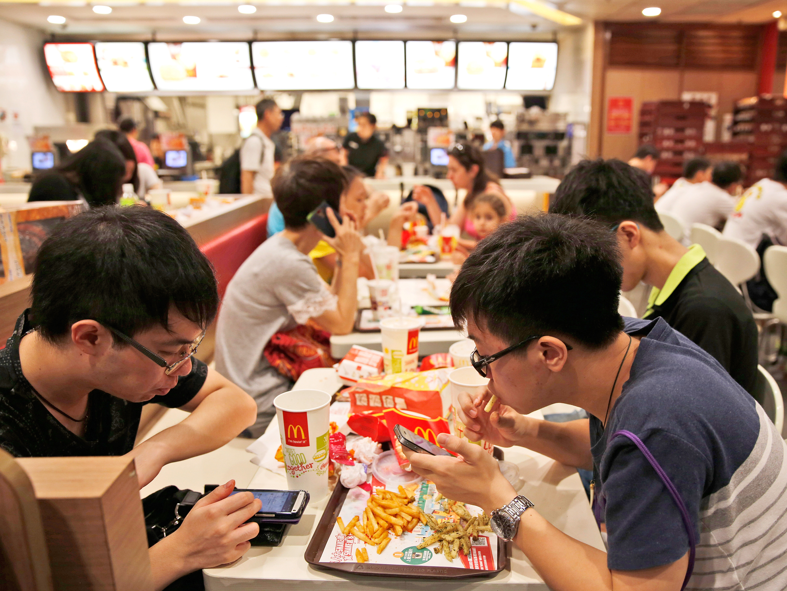 Customers eat at a McDonald's restaurant in Hong Kong Friday, July 25, 2014. McDonald's restaurants in Hong Kong have taken chicken nuggets and chicken filet burgers off the menu after a U.S.-owned supplier in mainland China was accused of selling expired meat. Photo: Kin Cheung/AP