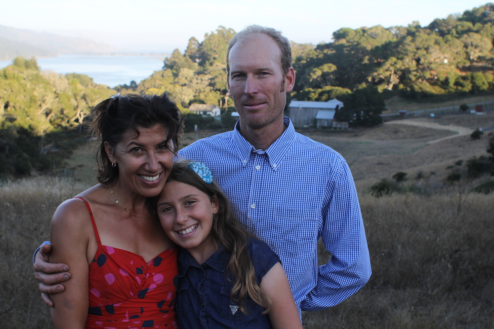 Ed Mann, Amanda Mann and their daughter stand in front of their farm on Horseshoe Hill. Photo: Angela Johnston