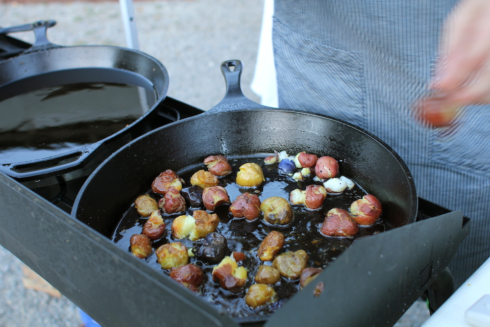 Thomson cooks potatoes for the second course. Photo: Angela Johnston