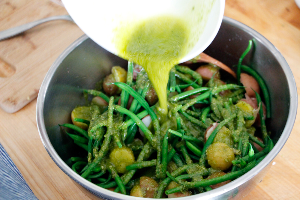 Pour the Lemon-Basil Pesto Vinaigrette over the potatoes and green beans and stir to coat evenly. Photo: Wendy Goodfriend