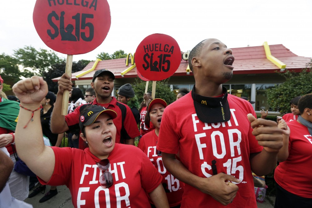 Protesters demonstrate outside a McDonald's in Chicago. Hundreds of workers from McDonald's, Taco Bell, Wendy's and other fast-food chains were expected to walk off their jobs Thursday to push the companies to pay their employees at least $15 an hour, according to labor organizers. Photo: M. Spencer Green/AP