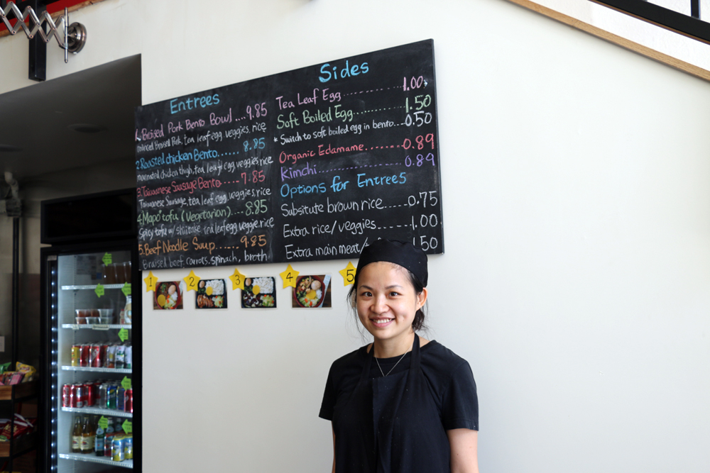 Executive chef and co-owner Stacy Tang in front of the hand-written bento menu at Taiwan Bento. Photo: Kim Westerman