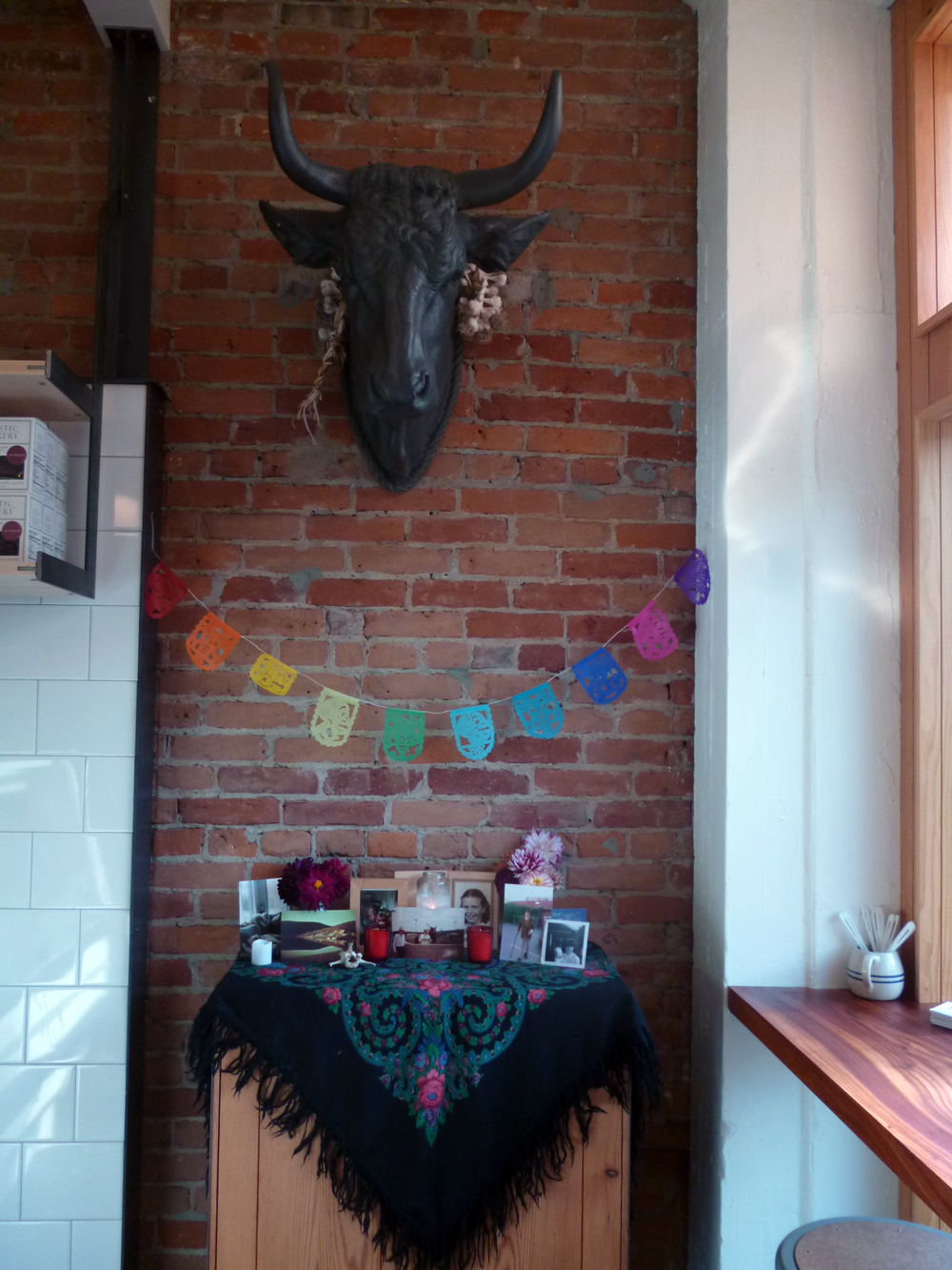 Day of the Dead display with bull head sculpture by David Best, father of Thistle Meats owner Molly Best.