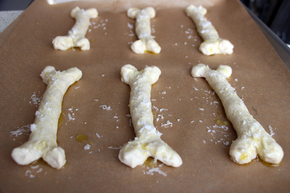 Space the bones evenly on the baking sheets. Brush with a thin layer of olive oil, then sprinkle evenly with as much Parmesan as you dare. Photo: Wendy Goodfriend