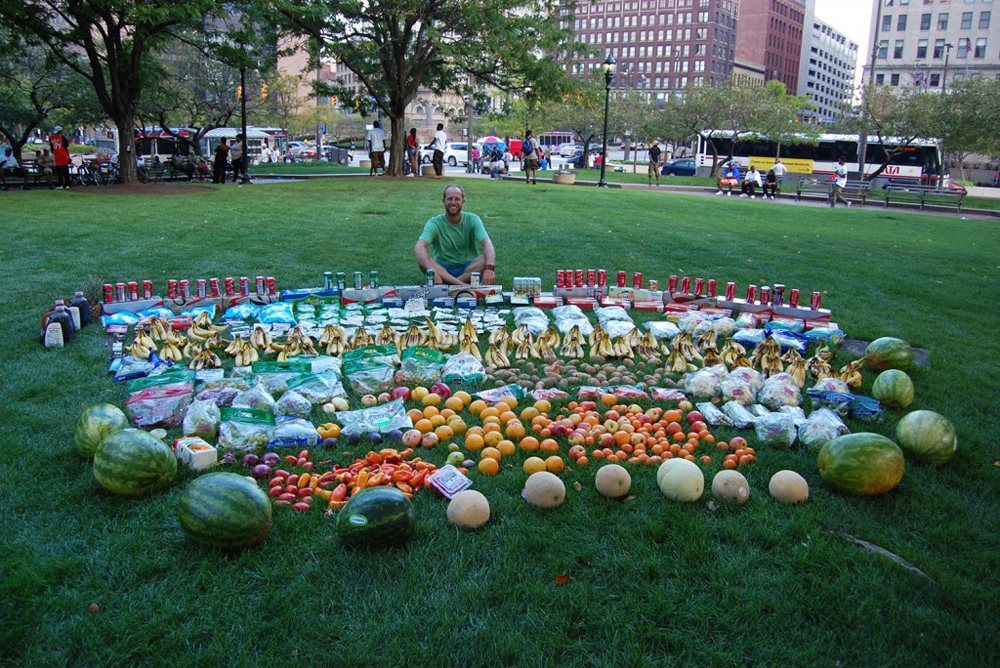Rob Greenfield has ridden his bicycle across the country, dumpster diving in various cities and making public displays of the food he finds to show how much food is regularly thrown out. Here he is shown with one of his displays in Cleveland, Ohio. Photo: Courtesy of Rob Greenfield
