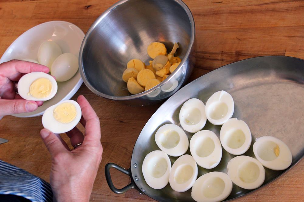 Peel the eggs, cut each one in half and scoop out the yolk into a mixing bowl. Photo: Wendy Goodfriend