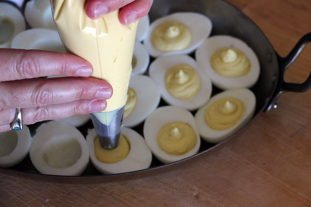 Fill a piping bag fitted with a plain medium tip. Pipe the filling into the egg white hollows. Photo: Wendy Goodfriend