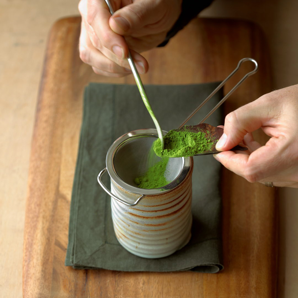 Matcha being sieved into a cup. Image courtesy of Breakaway Matcha