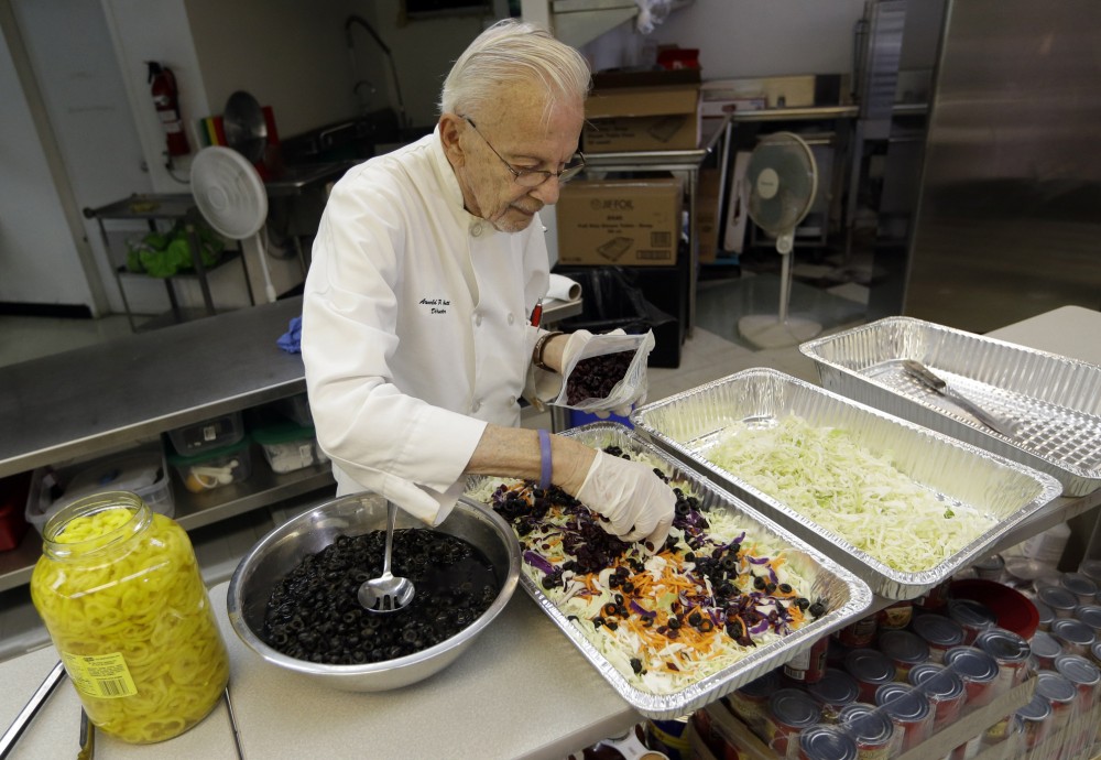 Homeless advocate Arnold Abbott, 90, director of the nonprofit group Love Thy Neighbor Inc., prepares a salad Wednesday in the kitchen of The Sanctuary Church in Fort Lauderdale, Fla. Abbott was recently arrested, along with two pastors, for feeding the homeless in a Fort Lauderdale park. Photo: Lynne Sladky/AP