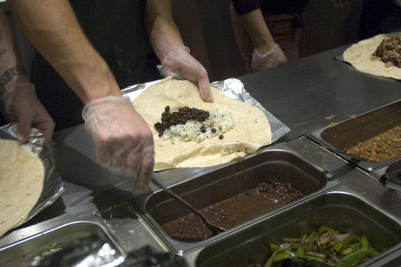   Workers prepare burritos at a Chipotle Mexican Grill in New York. The restaurant chain has stopped serving pork in about one-third of its U.S. locations.  Photo: Richard Levine/Demotix/Corbis 