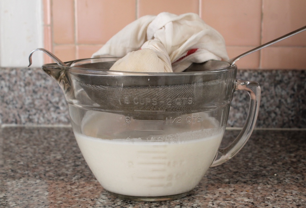 Squeeze and twist the dishtowel to press out all of the milk from the nuts. Photo: Kate Williams