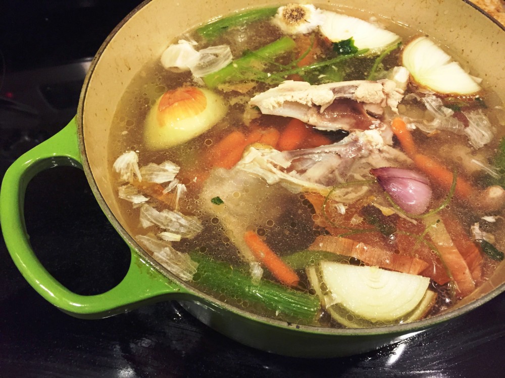 A pot of bone broth with aromatic vegetables about to be boiled. Poultry bone broth like this typically contains chicken feet and wings, which are rich in collagen and help to give the finished product its gelatinous consistency. Photo: Amy Blaszyk for NPR