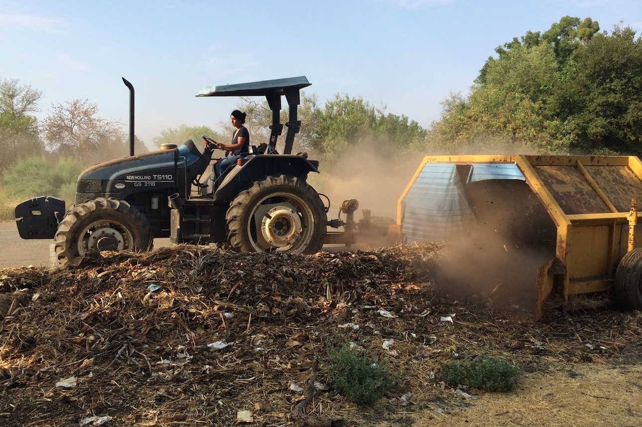 Former Director Nidhi Solanki of Project Compost uses a tractor and compost turner to turn food waste into compost. Photo: Sequoia Williams 