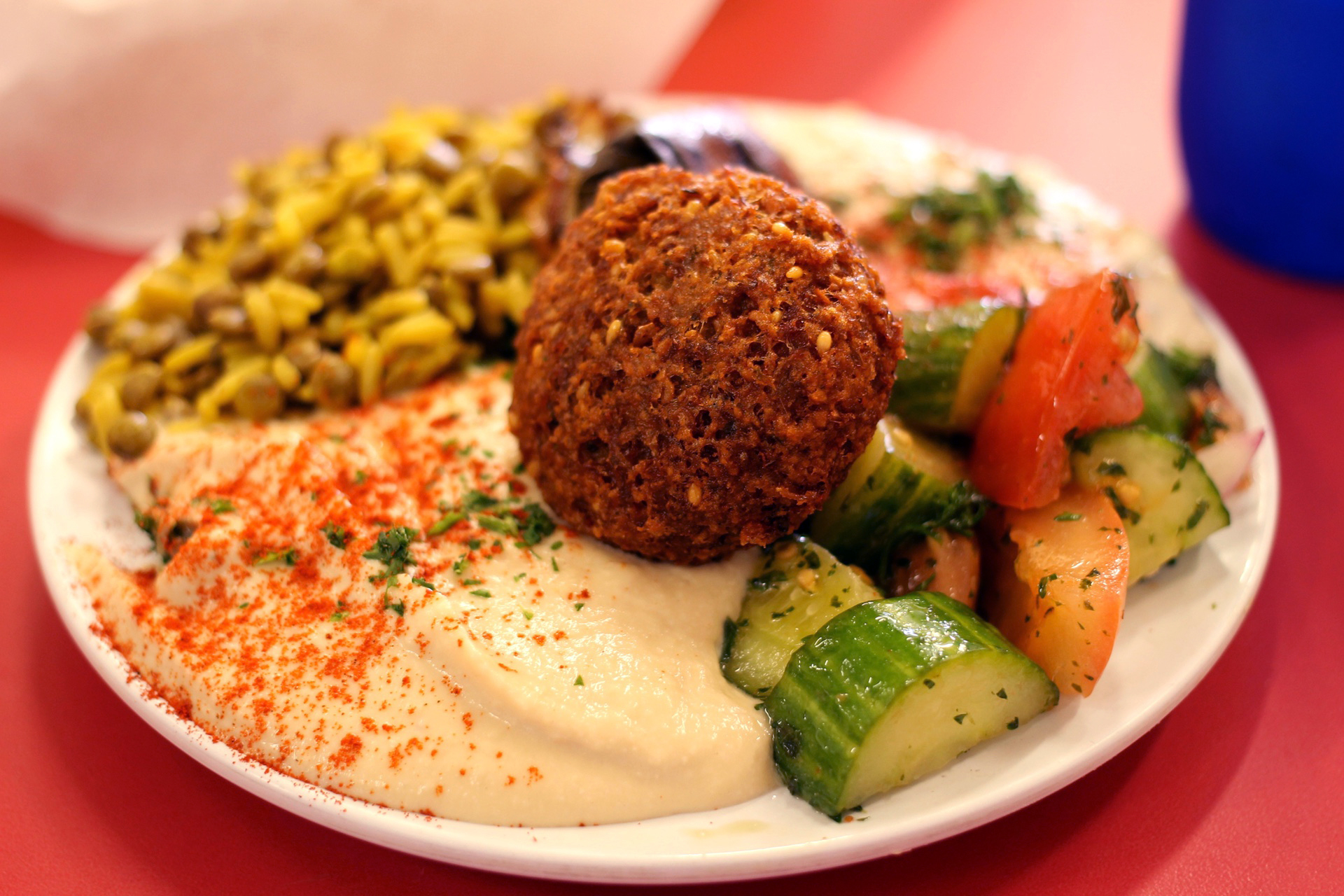 The vegetarian plate at Sunrise Deli in San Francisco includes falafel, hummus, cucumber salad, one dolma, lentils and rice.