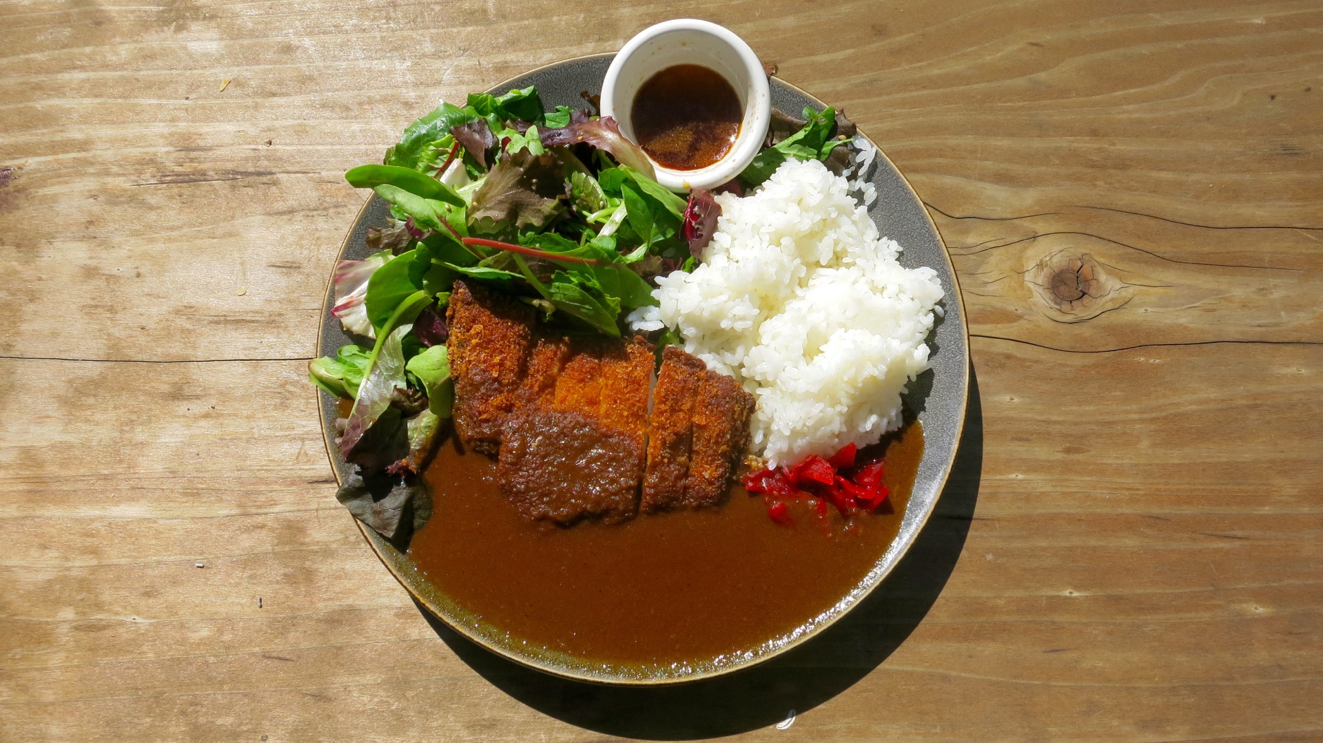 Juicy pork tonkatsu swims in a pool of savory curry sauce from AS B-Dama.