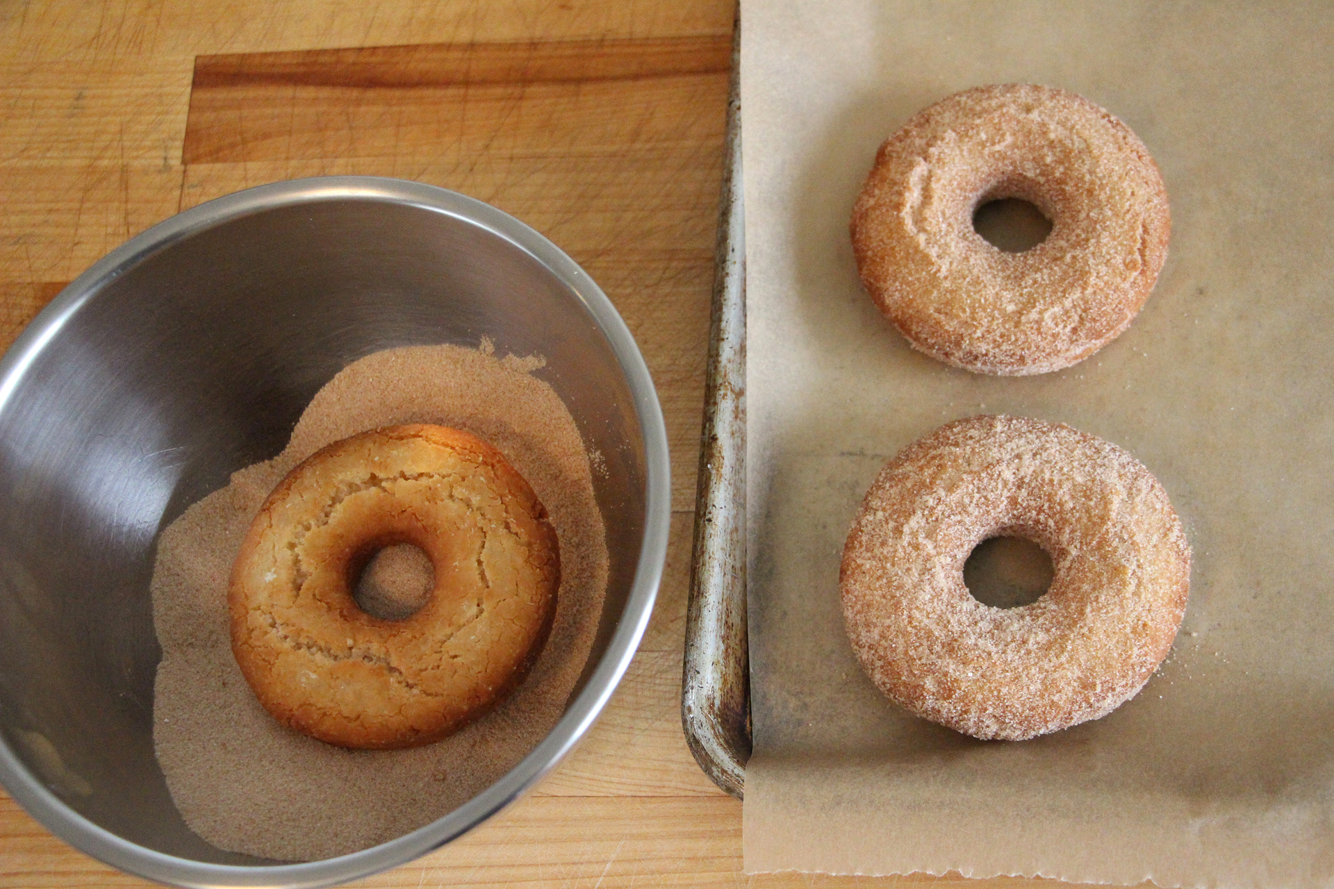 Toss the warm donuts and holes in the cinnamon-sugar.