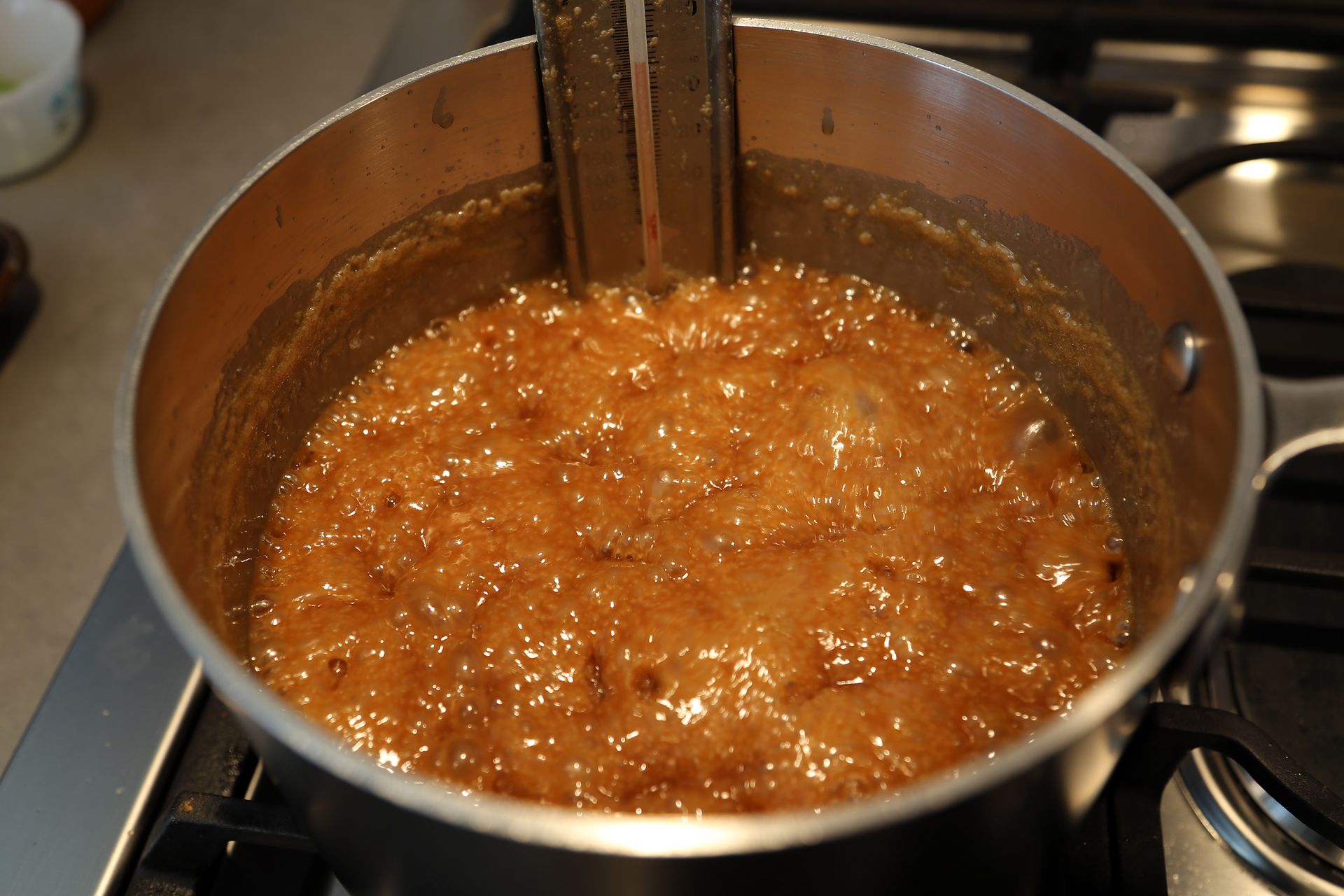 In a deep, heavy saucepan over medium heat, stir together the sugar, cream, corn syrup, butter, vanilla, and salt. Cook, swirling the pan occasionally, until the mixture is thick and syrupy and registers 245F.