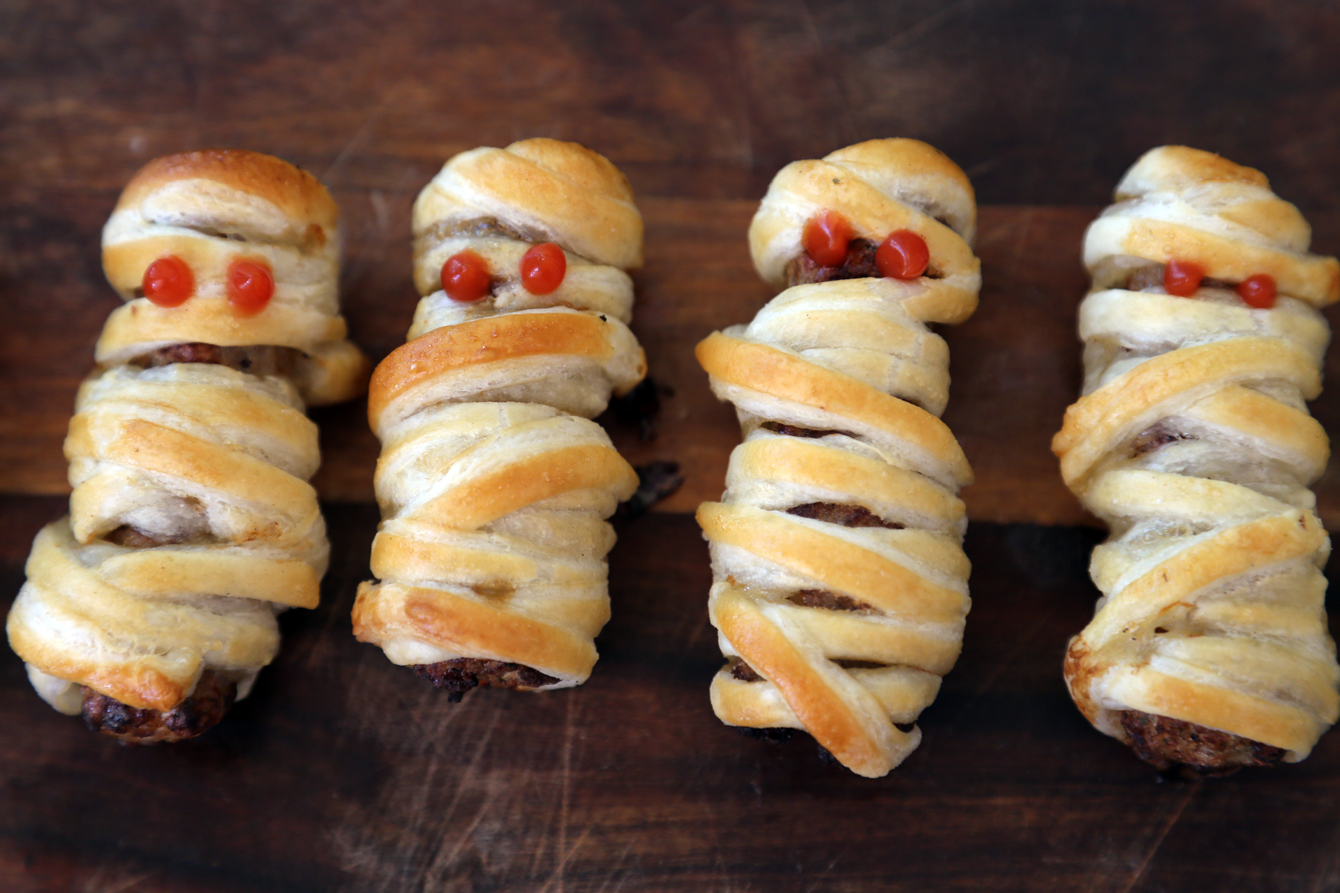 Serve the Mummy Sausage Rolls at once.