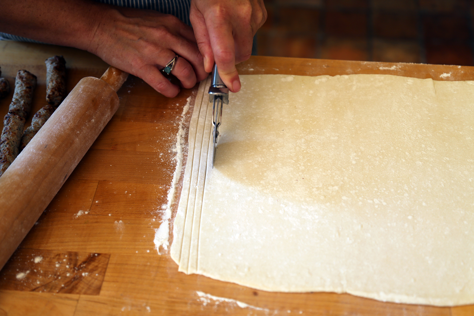 Using a pizza cutter, cut thin, 1/4-inch wide strips down the longer side of the pastry.