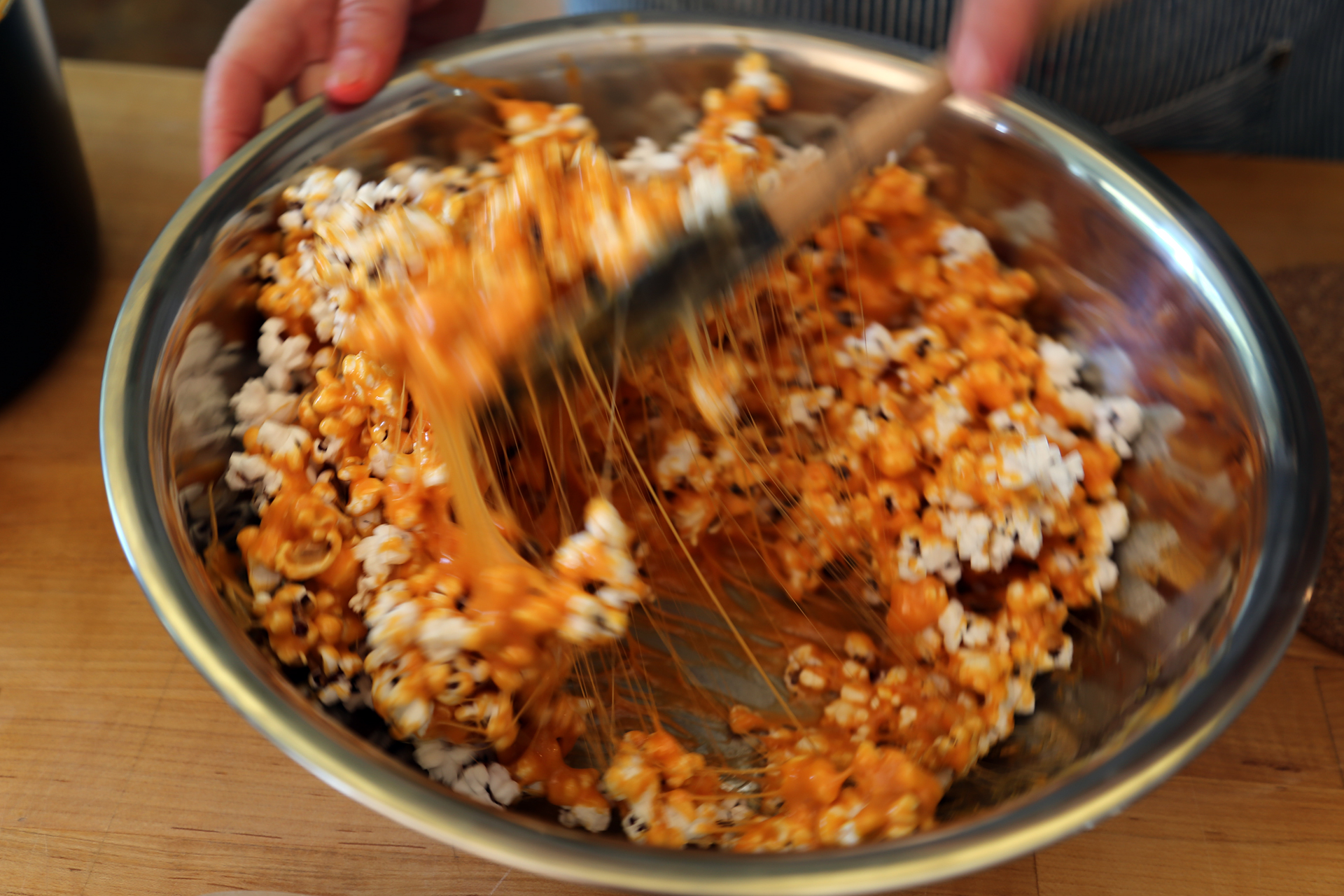 Pour the caramel mixture over the popcorn and stir to completely coat the popcorn.
