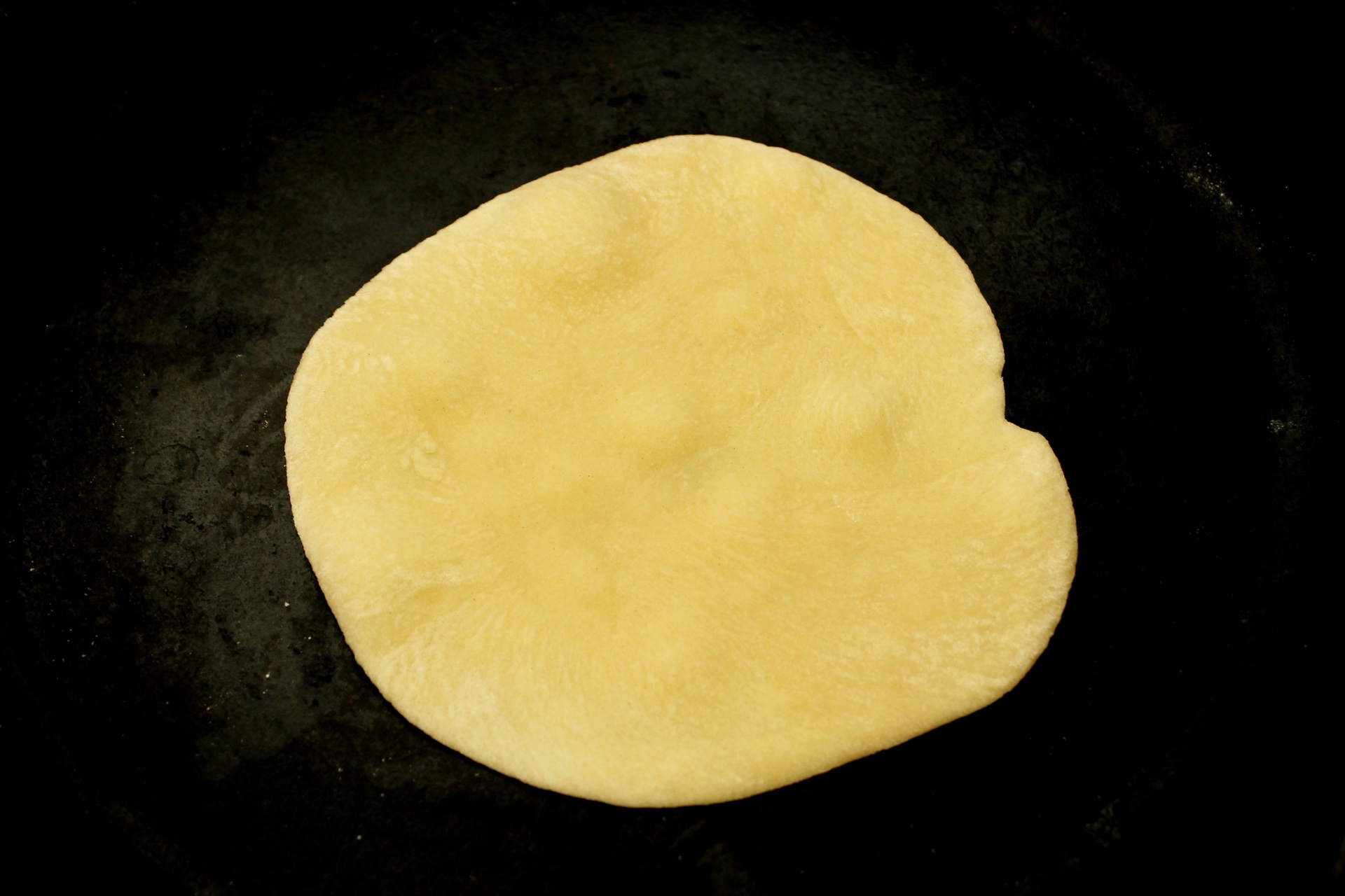 Let the tortilla cook on the first side until it begins to bubble.