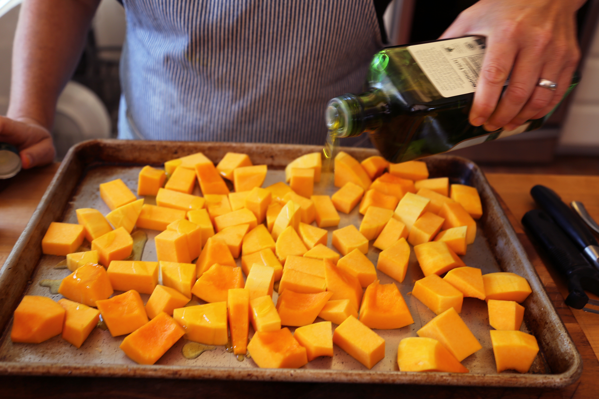 Place the butternut squash on a rimmed baking sheet and toss with a drizzle of olive oil and sprinkle with kosher salt. 