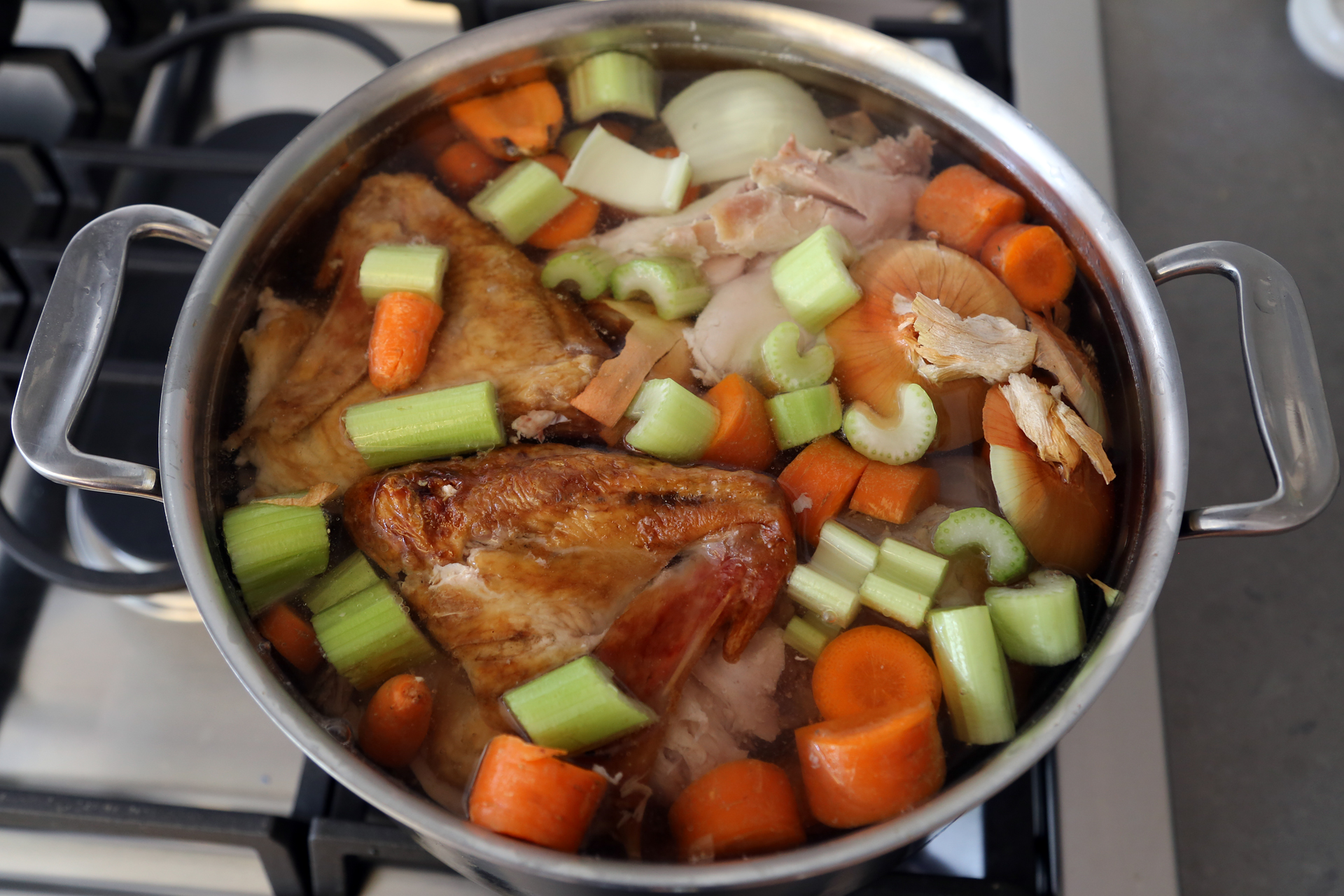 In a large stockpot, add the turkey and roasted vegetables, the onion, carrots, celery, and parsley.