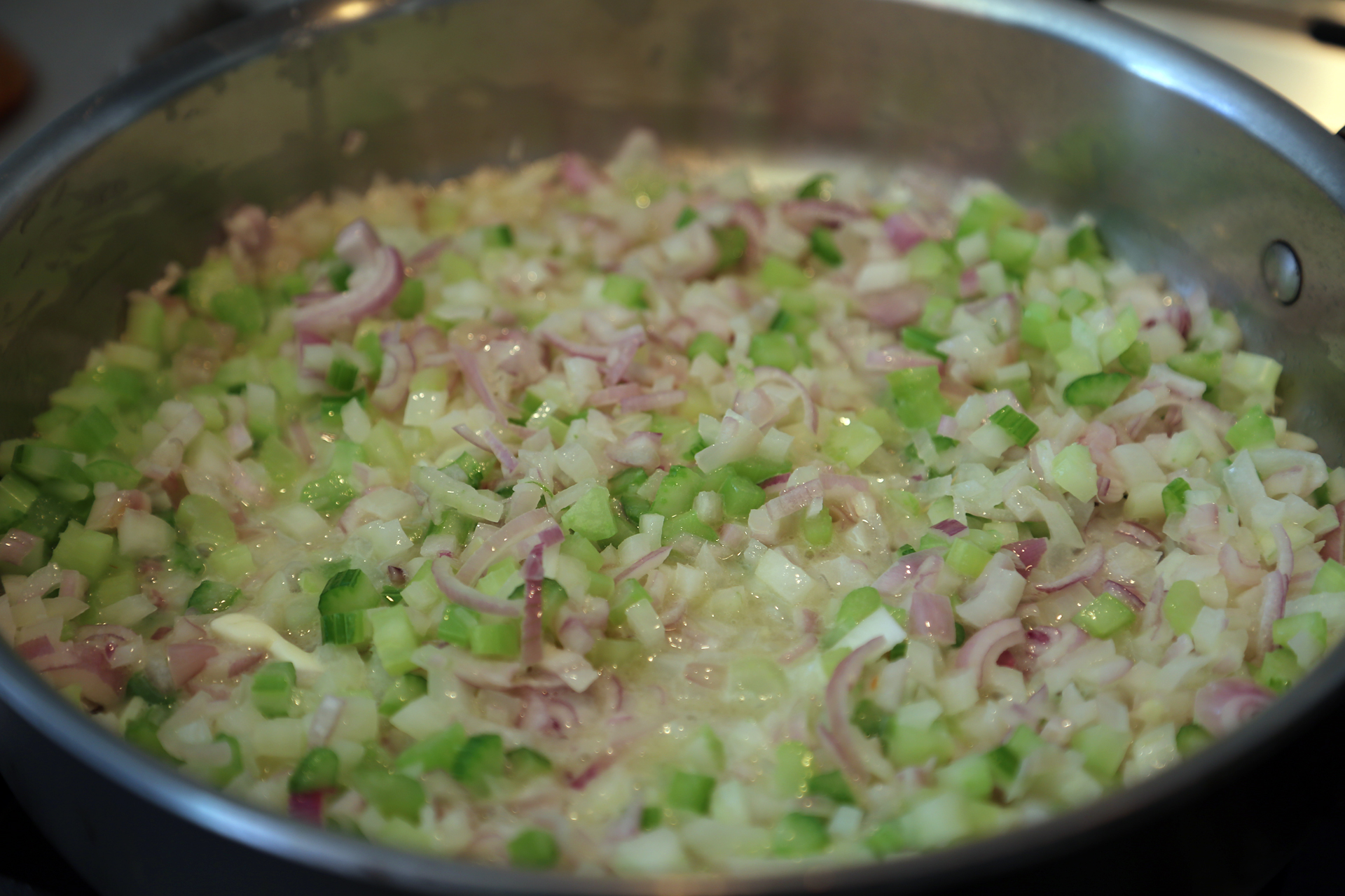 In a large frying pan, melt the butter over medium-high heat. Add the prepped onion, shallots, celery, and a pinch of salt.
