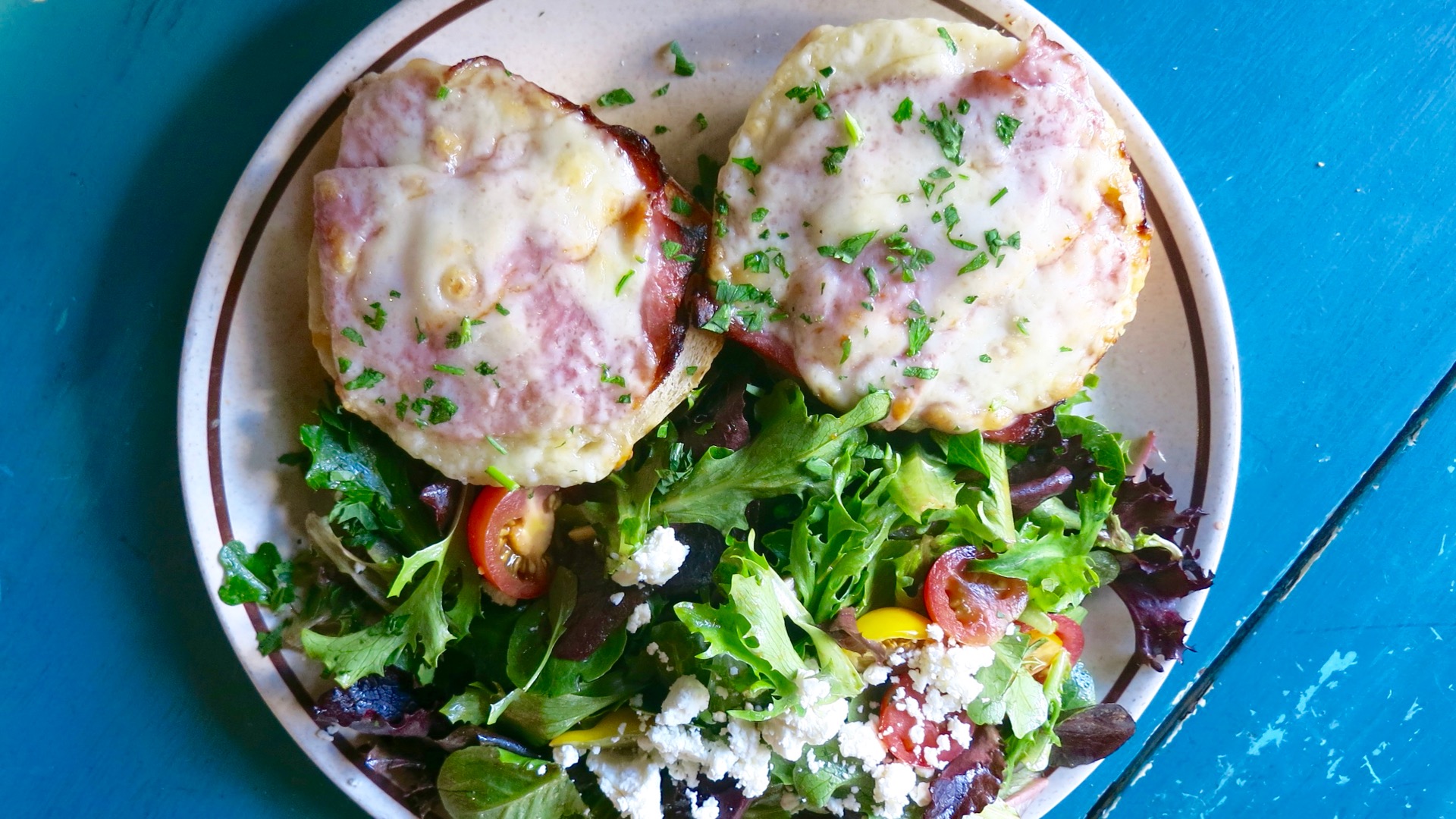 A perfect pairing for lunch: ham and cheese melt with a fresh side salad.