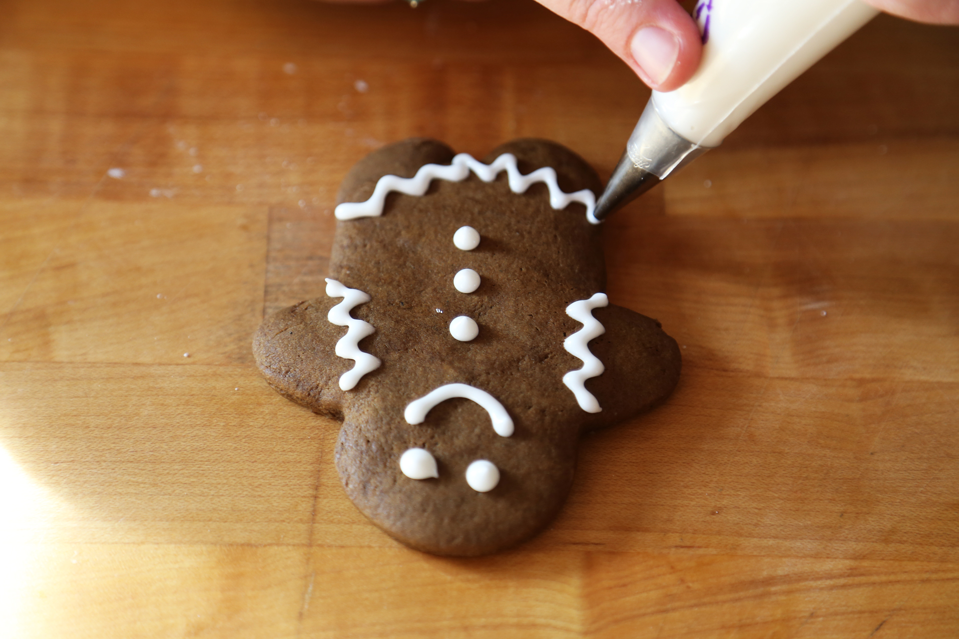 Decorating a gingerbread person with royal icing.