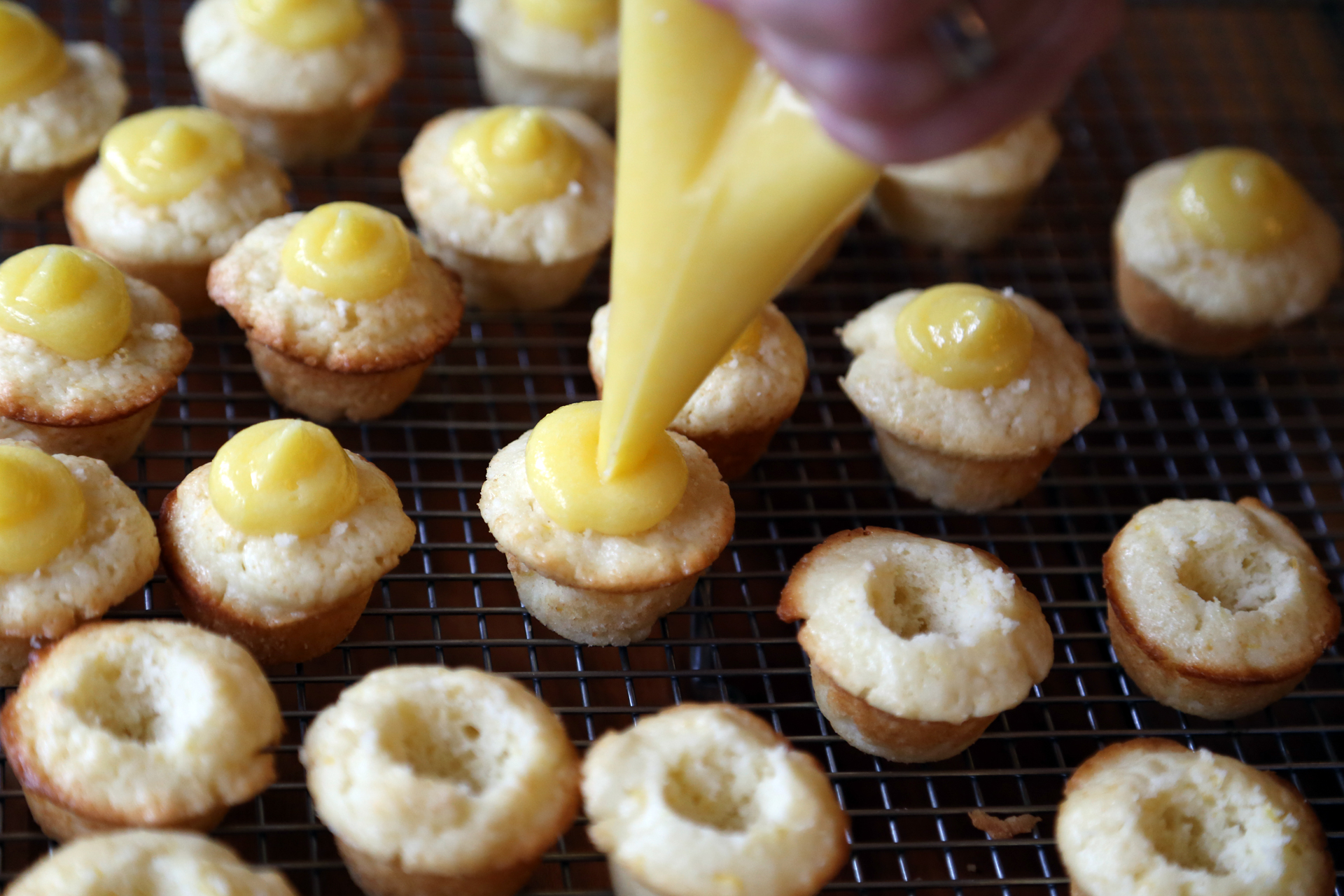Scoop the lemon curd into a pastry bag that is fitted with a plain tip or without a tip. Pipe the curd into the cup in the cupcake, letting it mound on the top.
