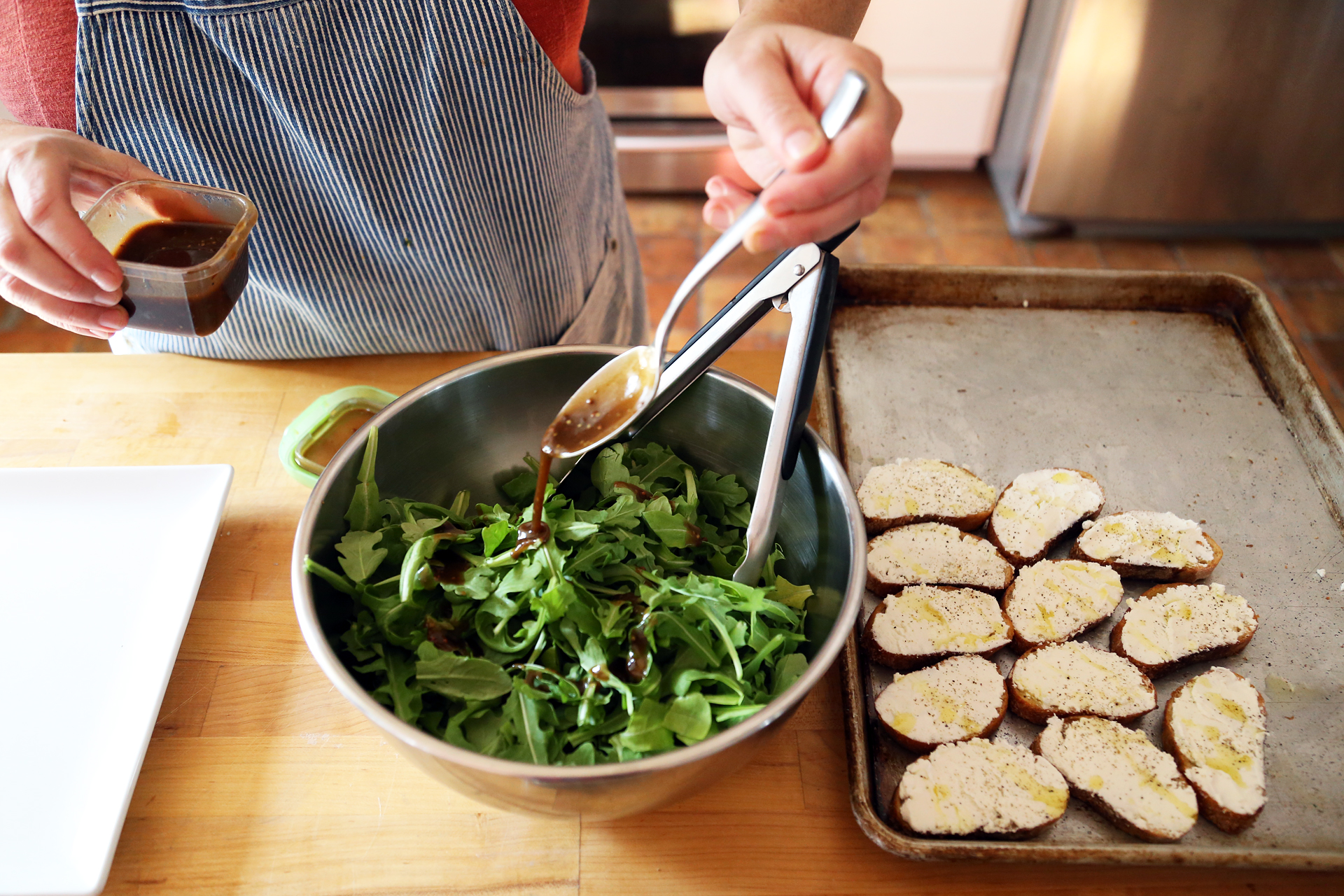 In a mixing bowl, toss the arugula with about 2 tbsp of the vinaigrette.