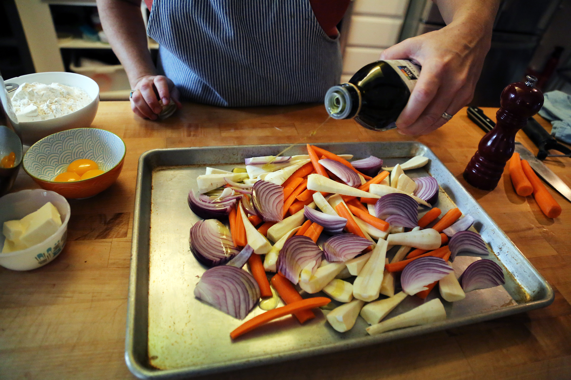 Cut the onion into wedges. Add the vegetables to a large rimmed baking sheet, drizzle with olive oil and toss to coat. 