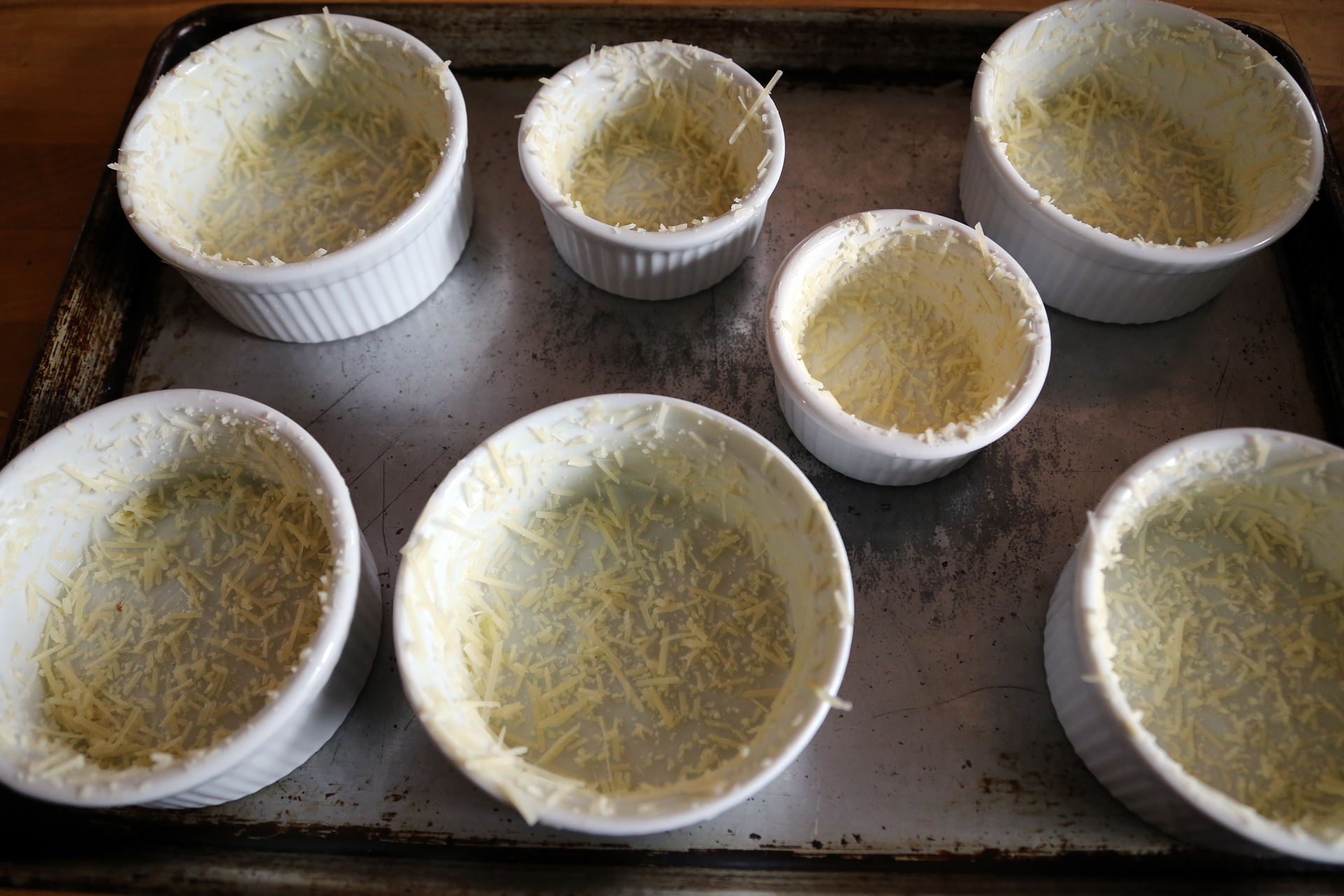 Generously butter the inside of six 1-cup ramekins, then coat lightly with Parmesan.