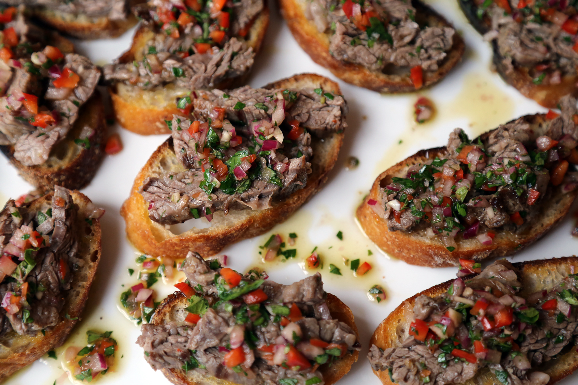 Add a few steak pieces to the top of each crostini and transfer to a serving platter.