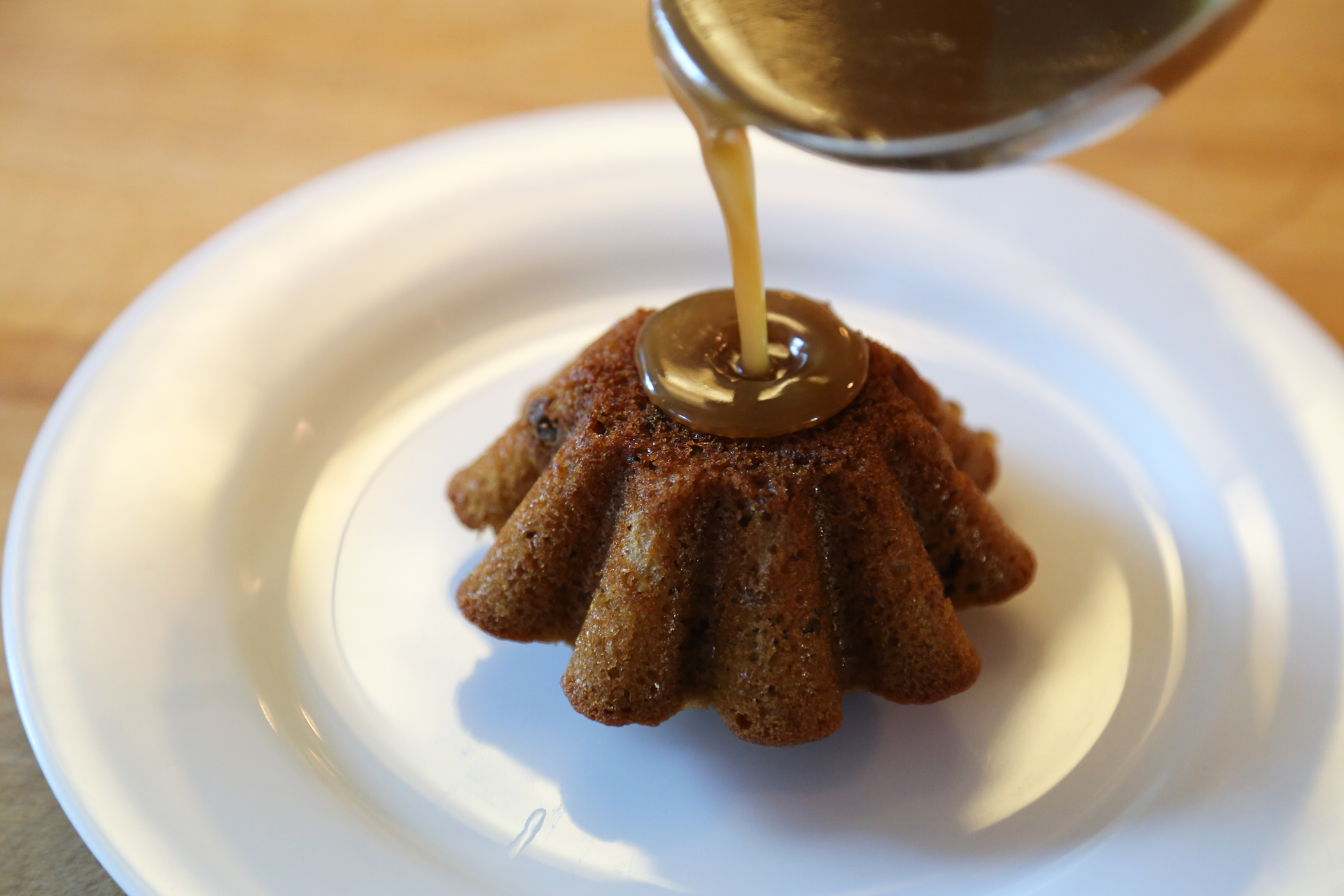 To serve the sticky toffee puddings, unmold each warm pudding onto a plate and top with a big spoonful of the sauce.