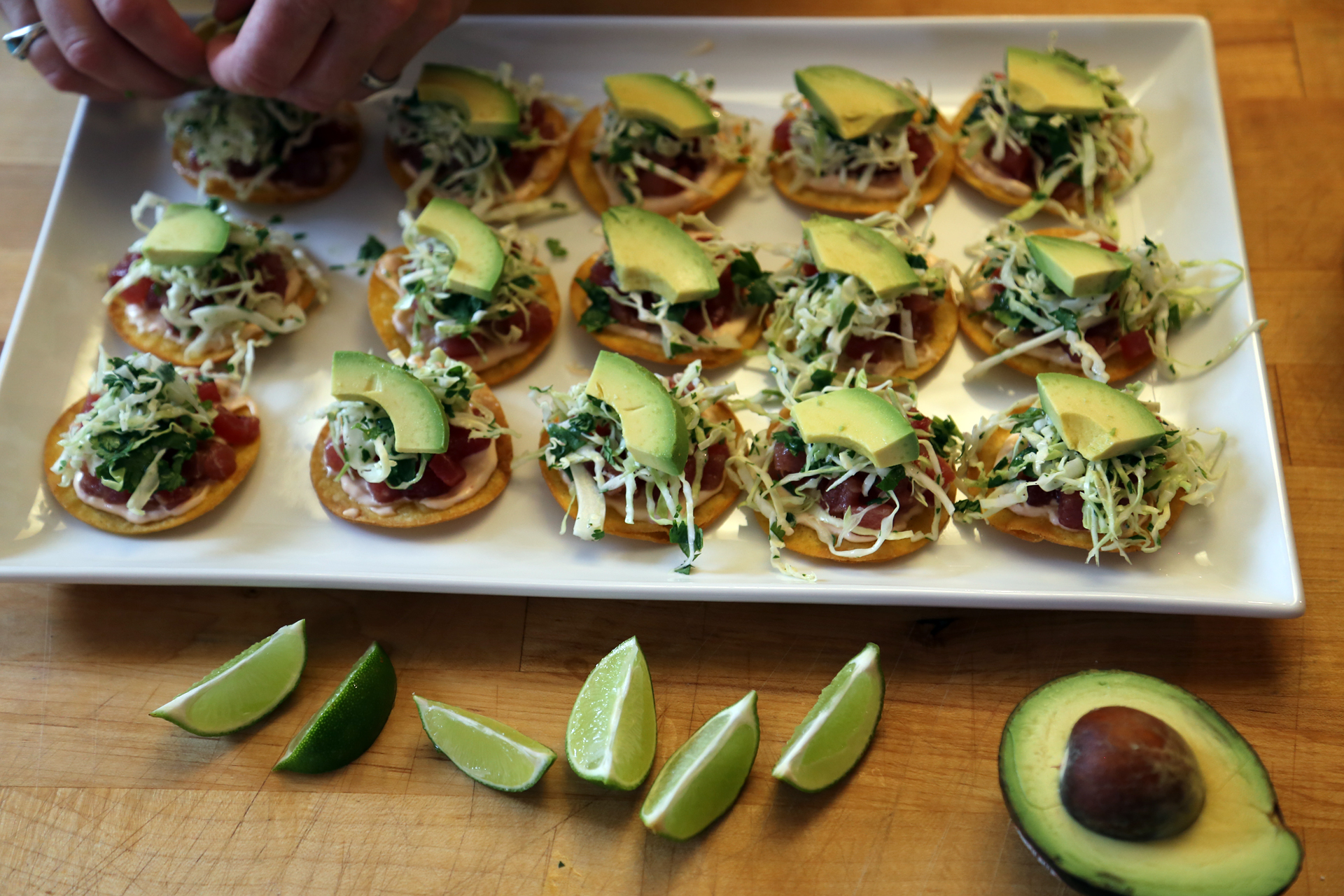 Add a slice of avocado to each tostada. Serve with the lime wedges alongside for squeezing.