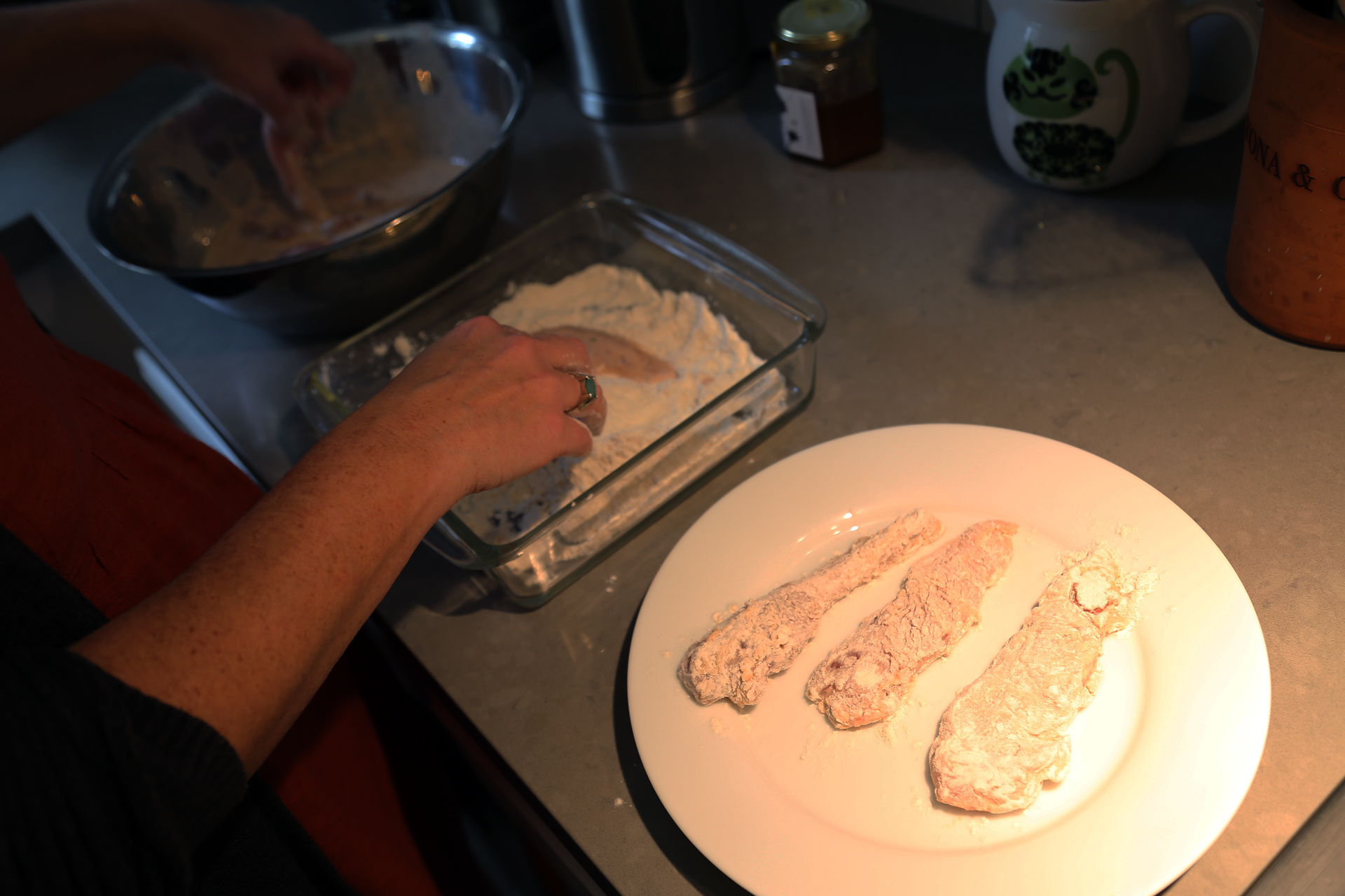 Pick up a chicken strip and let the buttermilk mixture drip off (but leave some of it coating the chicken). Dredge each strip in the flour mixture, coating it evenly, then set it aside on a plate.