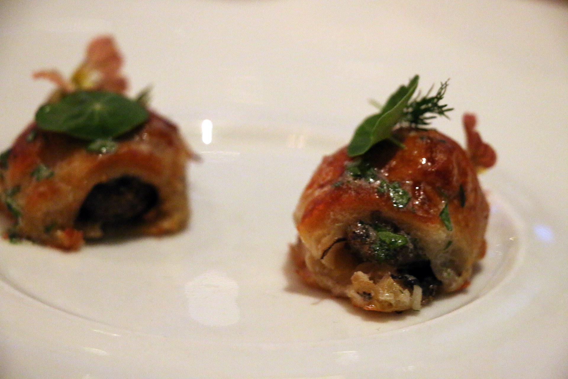 An amuse bouche of escargot bathed in chartreuse butter and tucked into a mini-croissant.