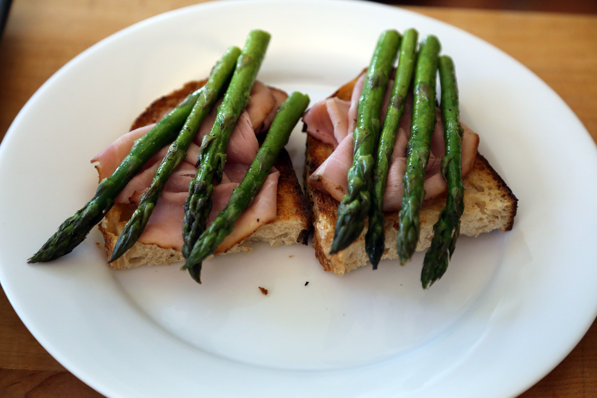 Divide the toast between warmed individual plates, using 1 or 2 slices per plate. Top each slice with a slice of ham, then divide the asparagus between the toasts.
