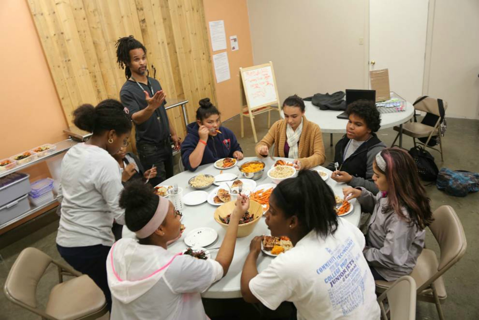 Teen volunteers eating together after cooking for the Clinic.