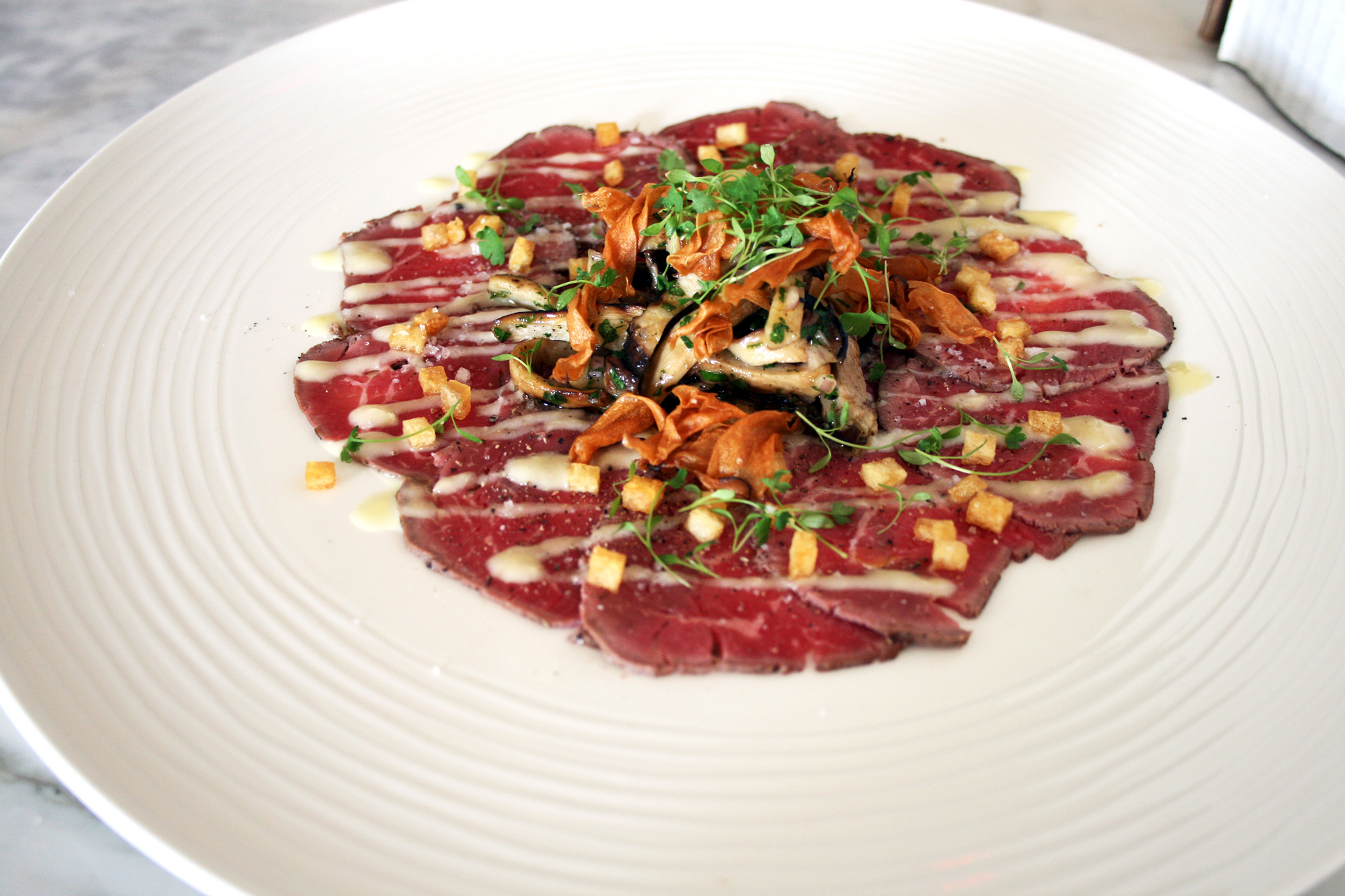 Beef Carpaccio — meltingly fatty, perfectly sliced and topped with sauteed trumpet mushrooms.