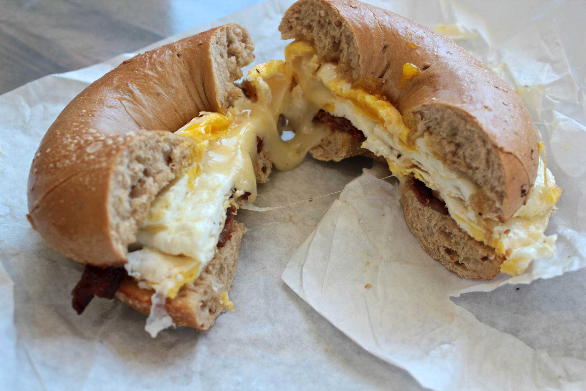 A Bagel Guy sandwich with a fried egg, pepper jack cheese and bacon on a multigrain bagel.
