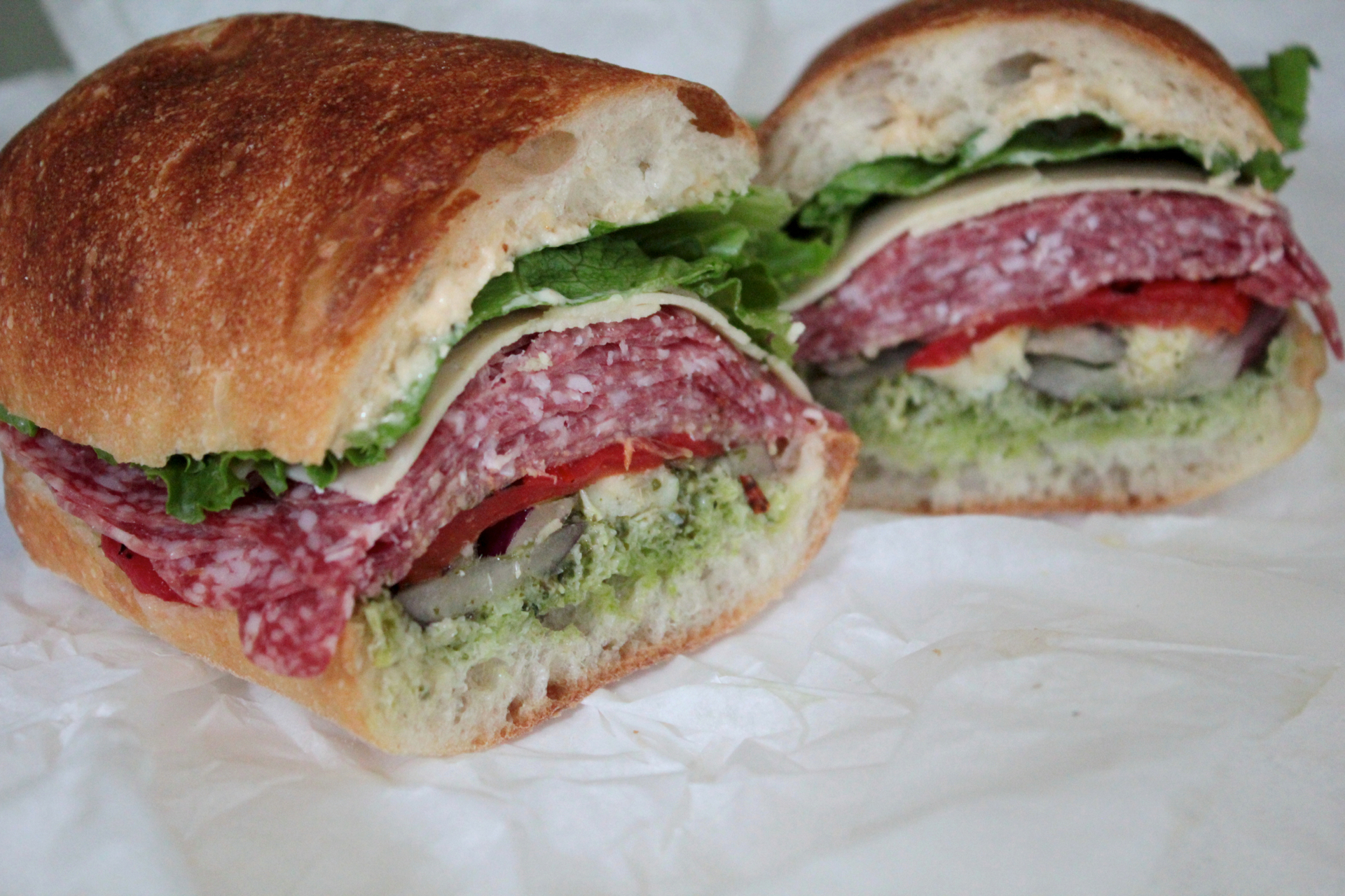 The Woodside Grand Champion features salami, artichoke hearts, red onions, red bell peppers, asiago and pesto.