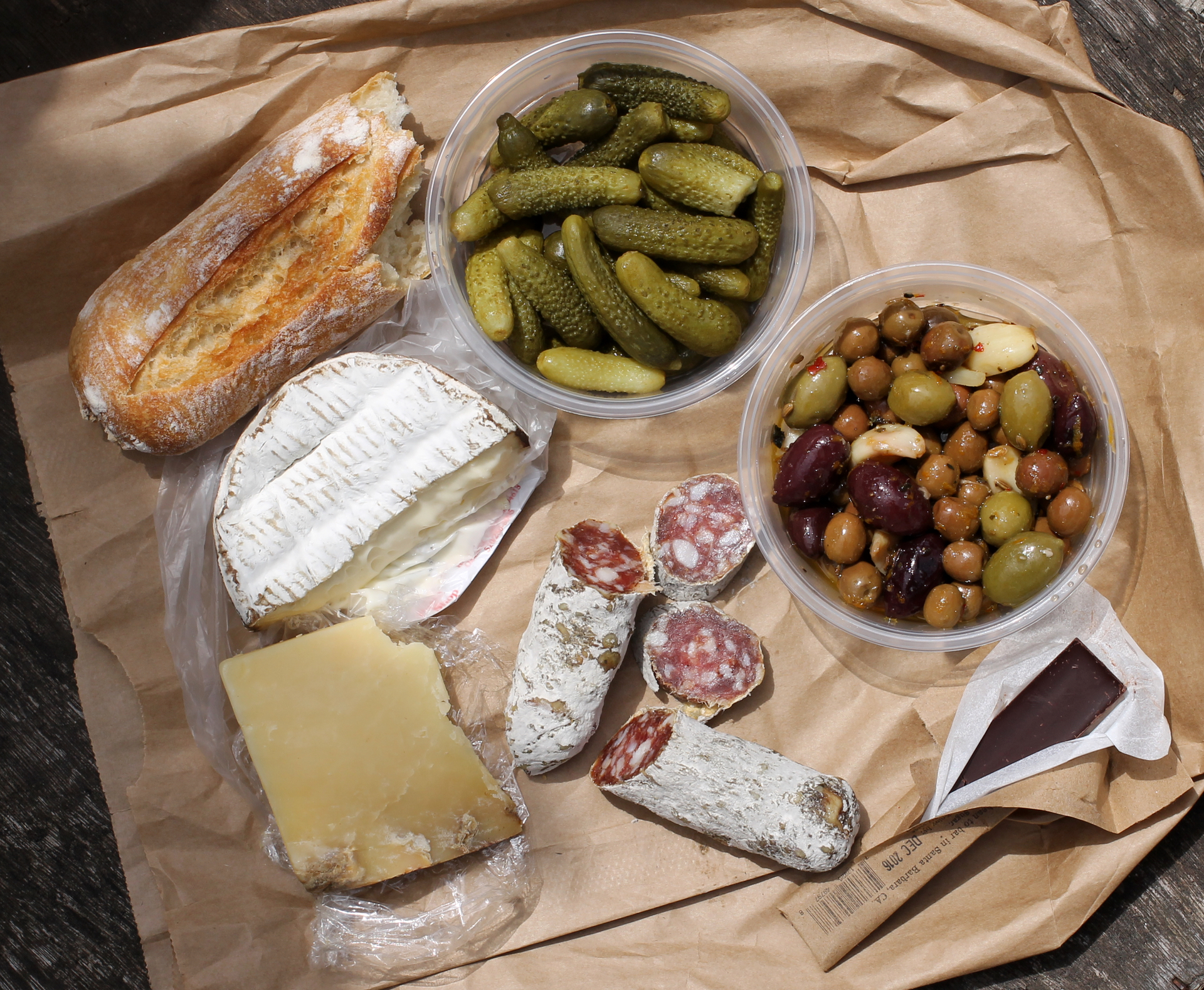 From top left, moving clockwise: Semifreddi’s baguette, cornichon, mixed olives, Twenty-four Blackbirds chocolate, Olympia Provisions sopressata, Montgomery’s Farmhouse cheddar, and Jasper Hill Harbison, all from The Pasta Shop.