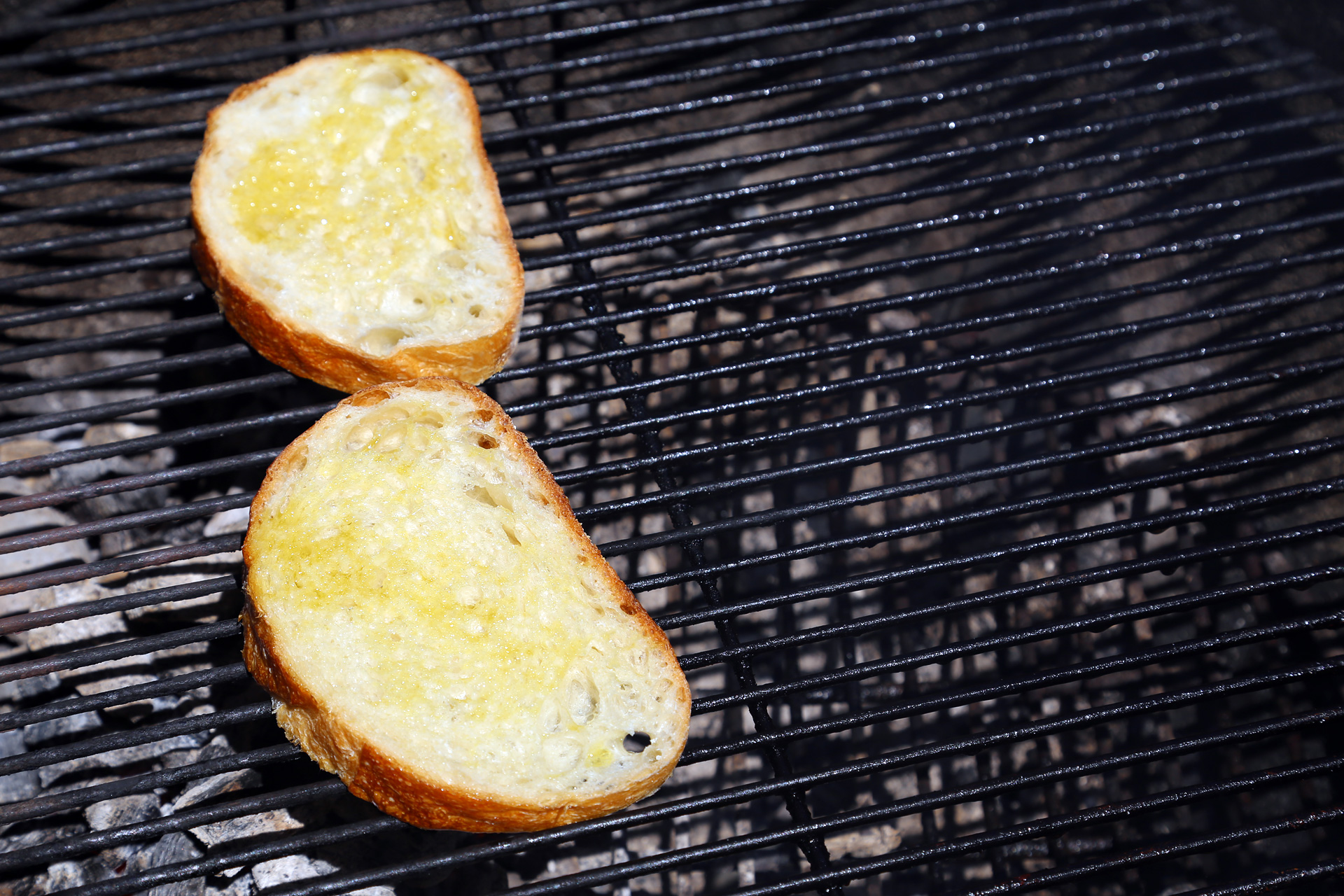Brush both sides of each bread slice with a little olive oil then place over the fire, turning once, until the bread is toasted and nicely grill-marked.