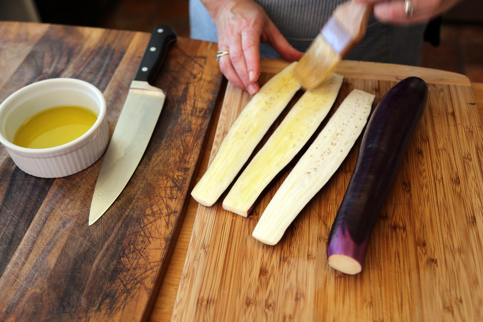 Trim the eggplant and slice it lengthwise into 1/2-inch pieces. Brush it with olive oil.