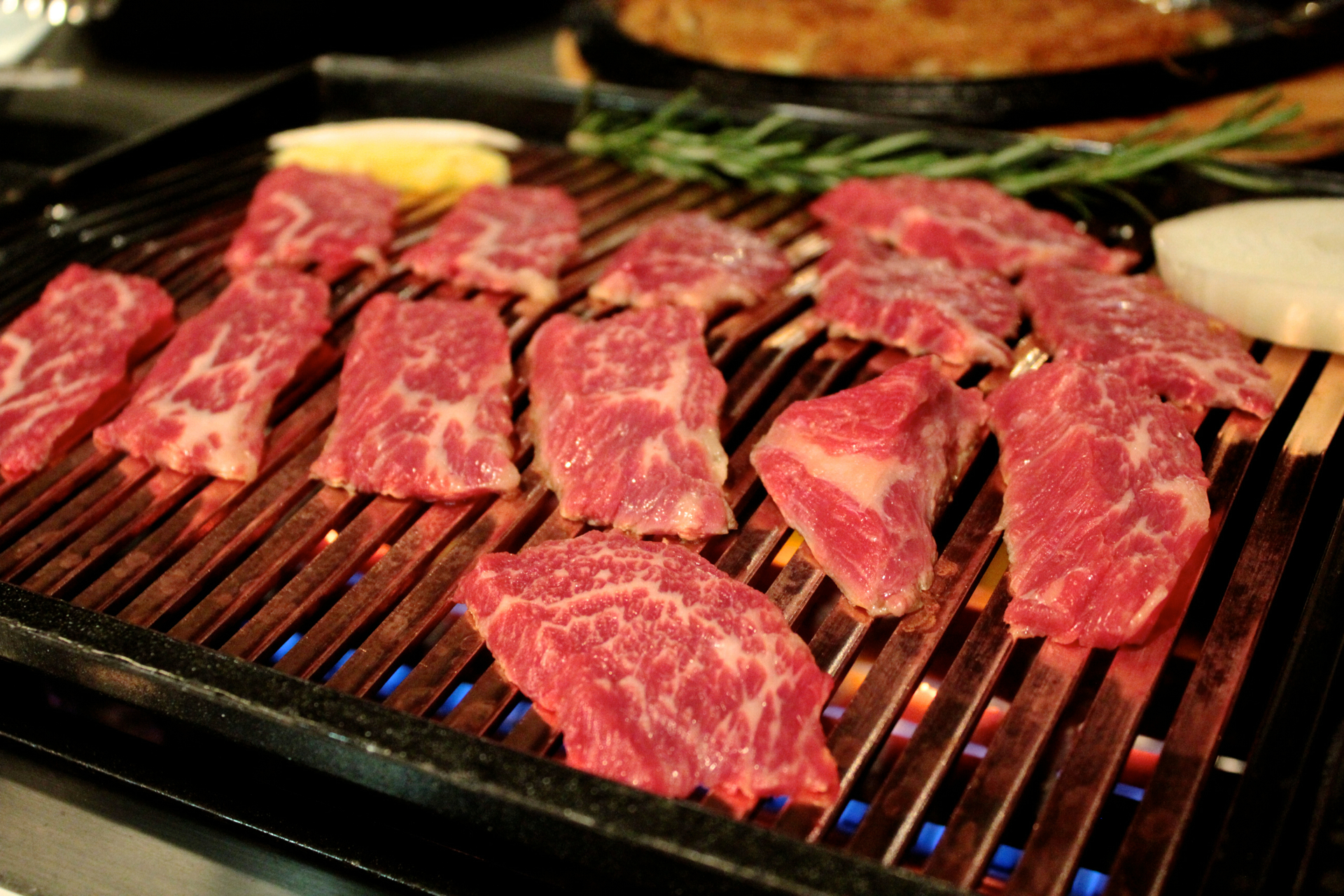 Slices of boneless short rib cooking on the grill at Chungdam.